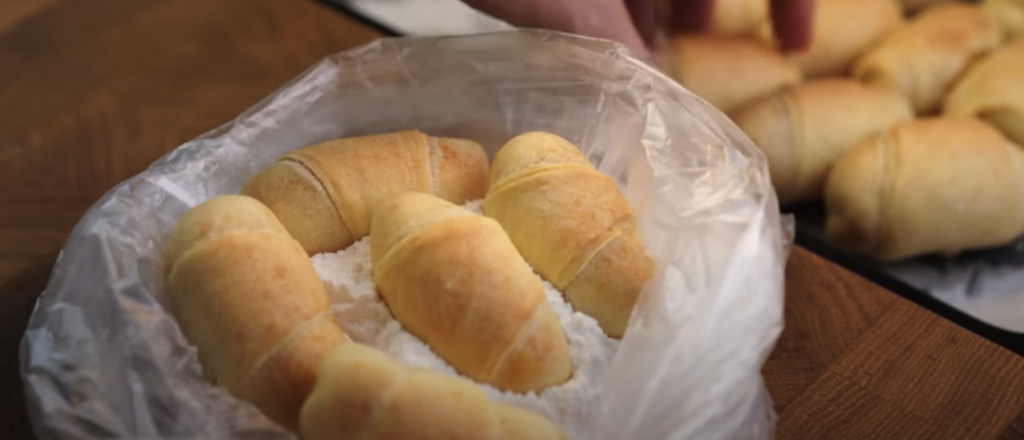 Křehké pomerančové croissanty z jogurtového těsta s moučkovým popraškem