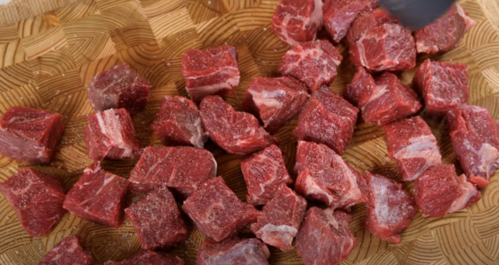 Pomalu dušené hovězí na červeném víně s kořenovou zeleninou a žampiony, podávané s jemnou bramborovou kaší