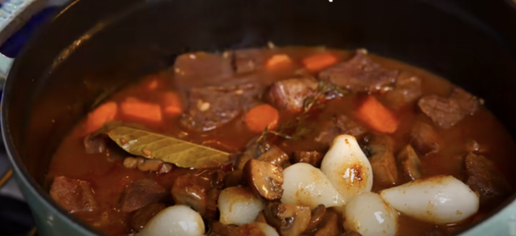 Pomalu dušené hovězí na červeném víně s kořenovou zeleninou a žampiony, podávané s jemnou bramborovou kaší