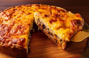 Slaný bramborový koláč ve tvaru pizzy s mletým masem, zeleninou a mozzarellou