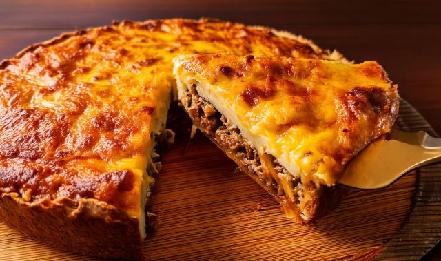 Slaný bramborový koláč ve tvaru pizzy s mletým masem, zeleninou a mozzarellou