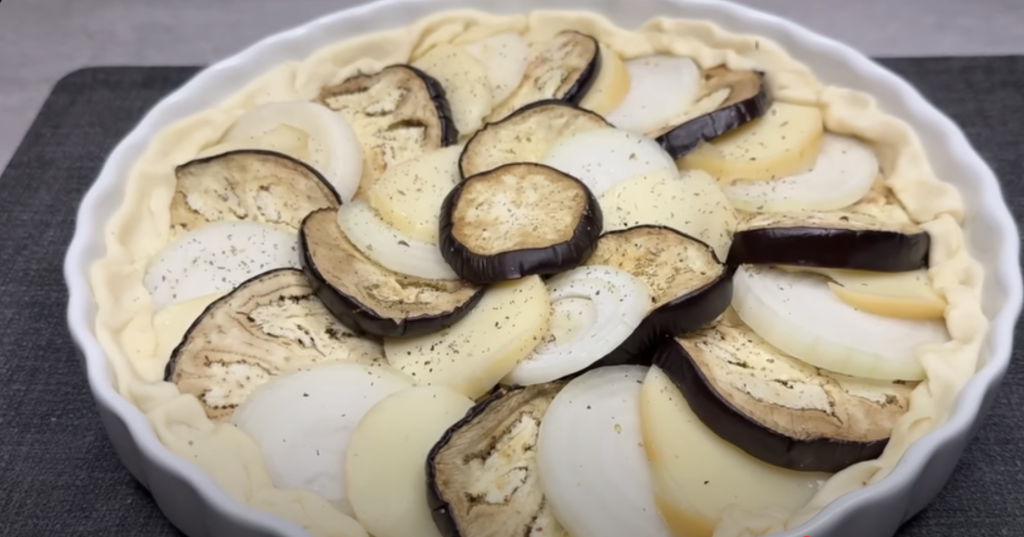 Slaný koláč z listového těsta s lilkem, karamelizovanou cibulí a uzeným sýrem