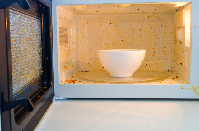 Open microwave. Dirt from food inside. Close up Čištění mikrovlnné trouby.