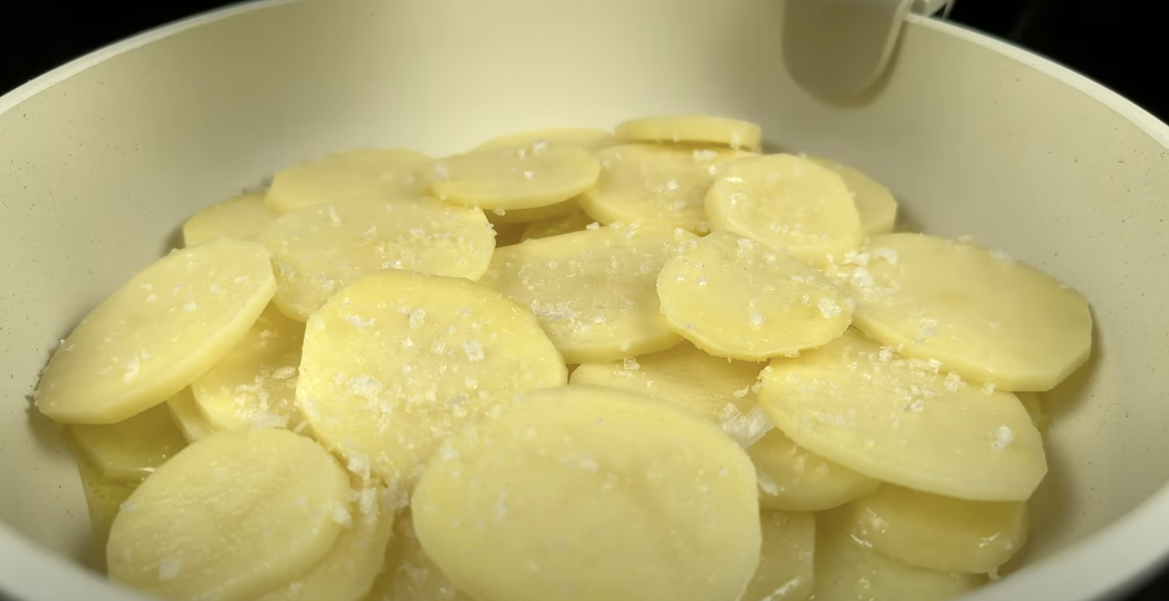 Nakrájené brambory na pánvi.