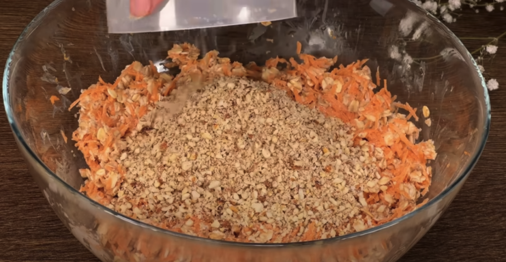 Vrstvený mrkvový dort s datlemi, vločkami, pomerančovým krémem a mandlemi