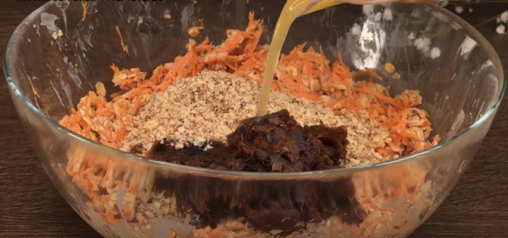 Vrstvený mrkvový dort s datlemi, vločkami, pomerančovým krémem a mandlemi