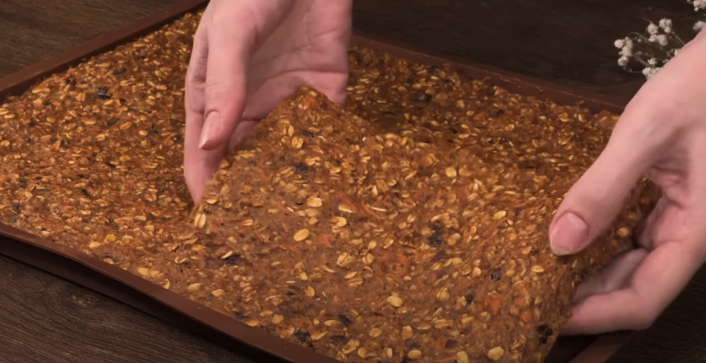 Vrstvený mrkvový dort s datlemi, vločkami, pomerančovým krémem a mandlemi