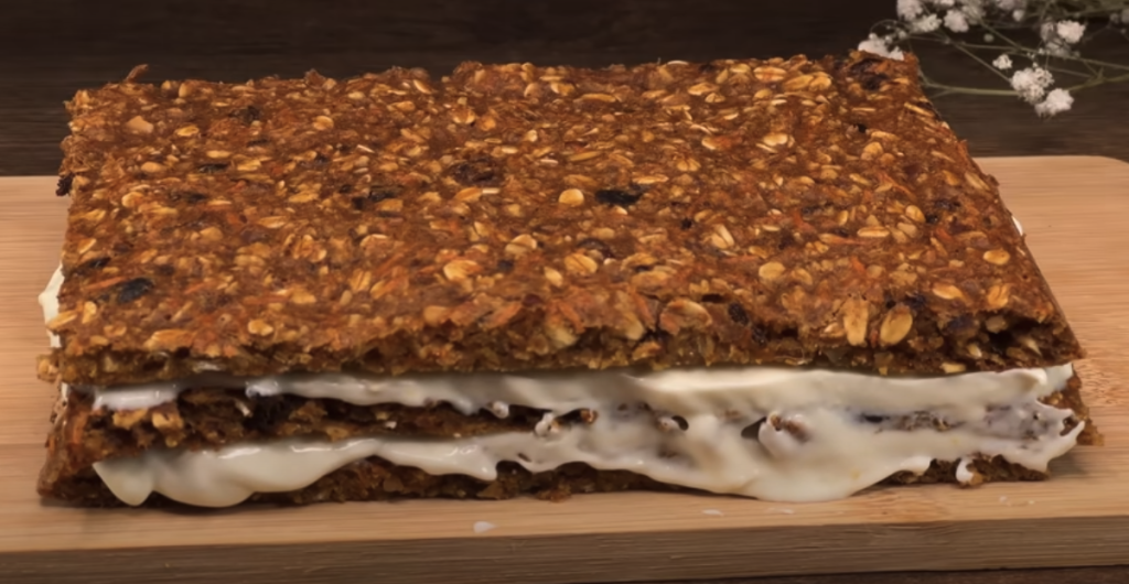 Vrstvený mrkvový dort s datlemi, vločkami, pomerančovým krémem a mandlemi
