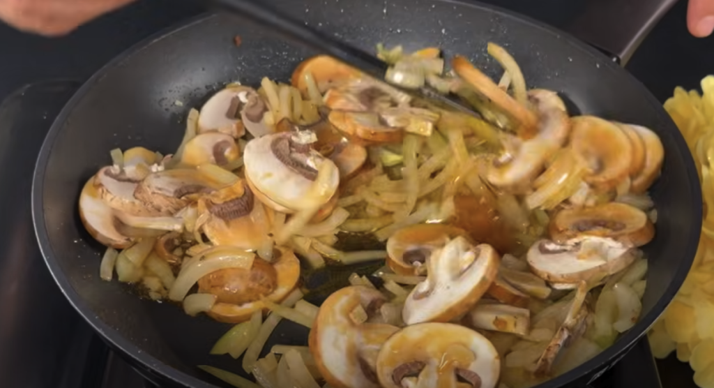 Kuřecí stehna v krémové žampionové omáčce s parmazánem a restovanými bramborami s cibulkou