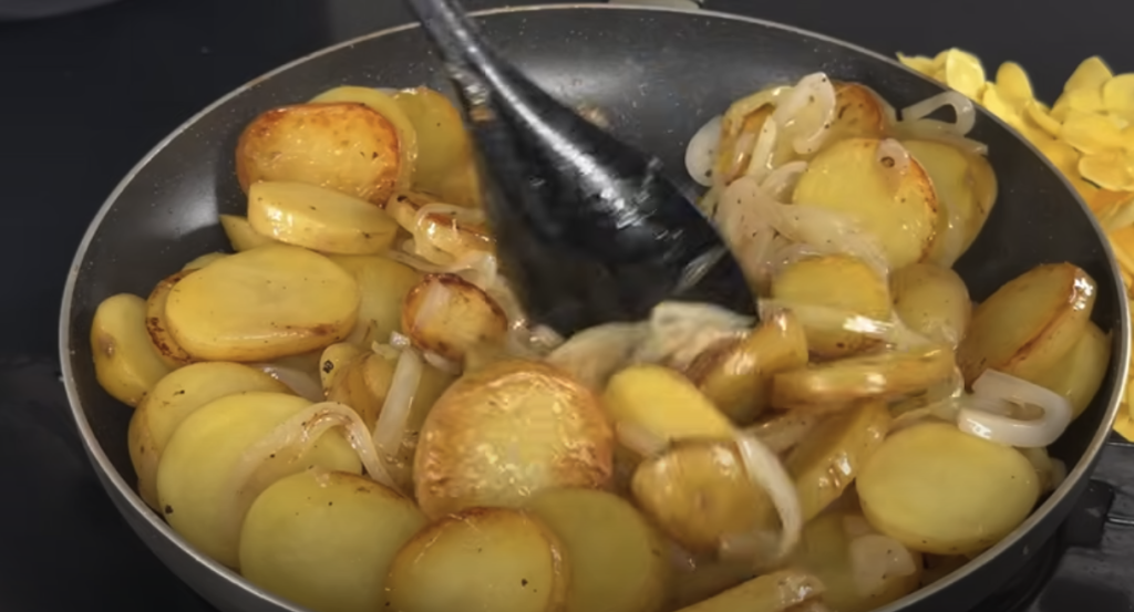 Kuřecí stehna v krémové žampionové omáčce s parmazánem a restovanými bramborami s cibulkou