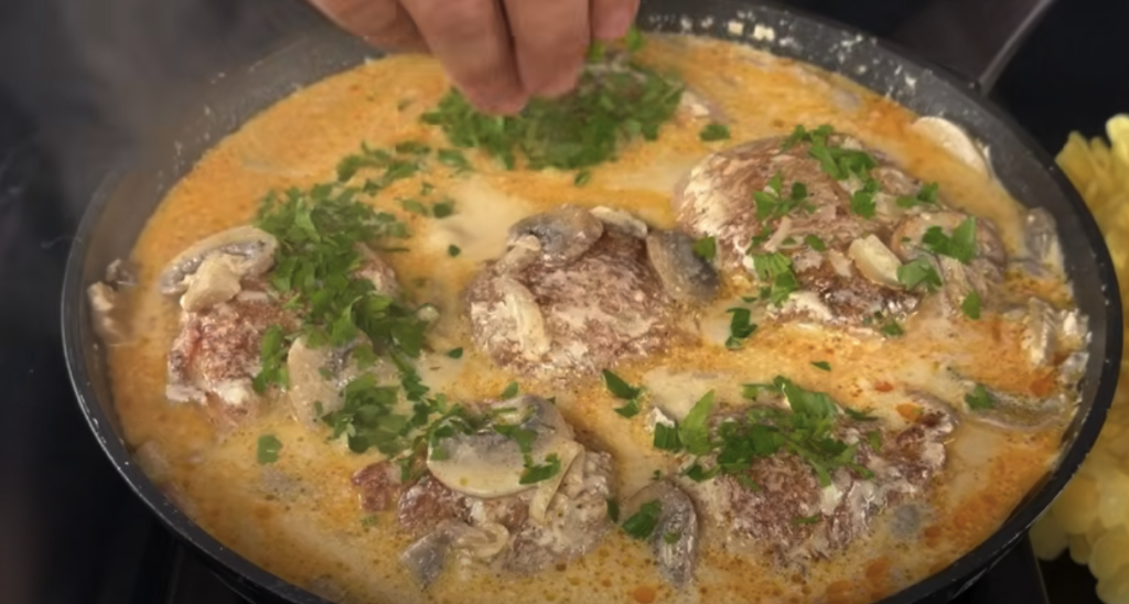 Kuřecí stehna v krémové žampionové omáčce s parmazánem a restovanými bramborami s cibulkou