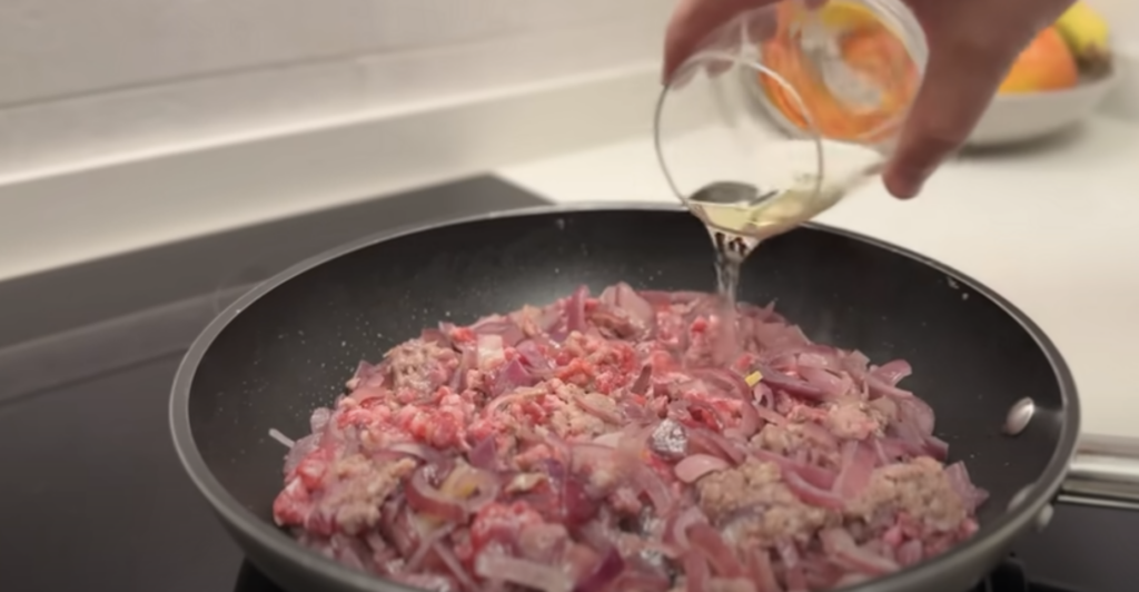 Gratinované vrstvené lilky s cibulovo-klobásovou směsí a sýrem