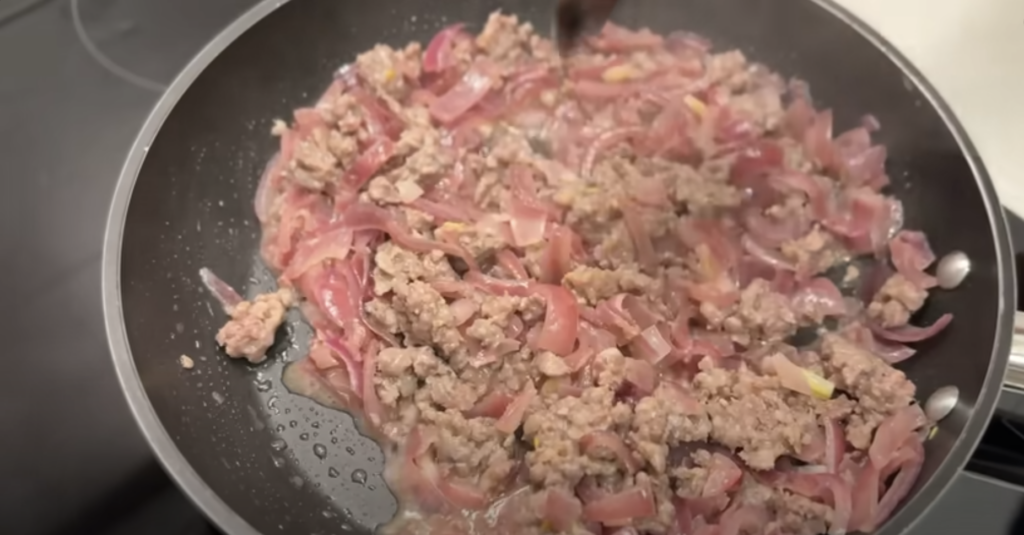 Gratinované vrstvené lilky s cibulovo-klobásovou směsí a sýrem