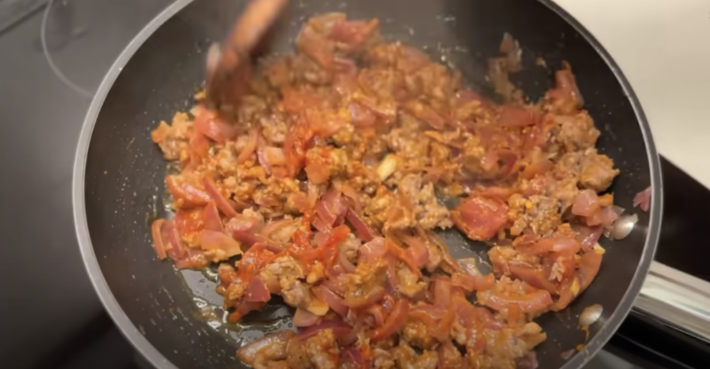 Gratinované vrstvené lilky s cibulovo-klobásovou směsí a sýrem
