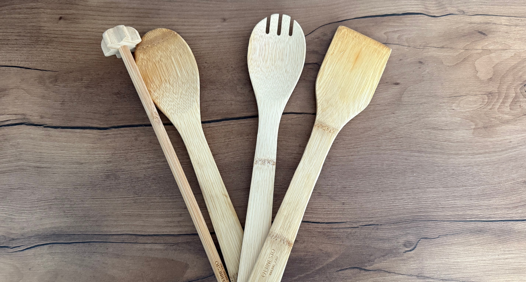 Dřevěné vařečky a obracečky položené na pracovní desce.