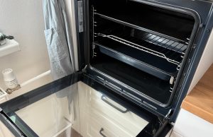 Trouba jako nová: vyčistěte ji snad bez drhnutí díky tabletě do myčky Otevřená kuchyňská trouba s vytaženými rošty.