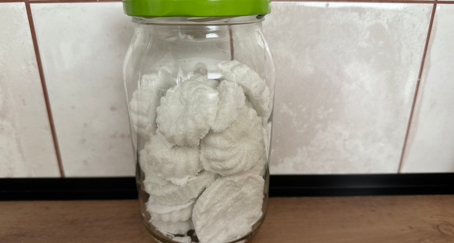 Sklenice plná domácích WC bomb na kuchyňské lince.