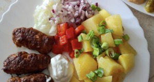 Domácí čevabčiči z trouby s bramborem a okurkovým salátem – voňavá klasika, která nezklame
