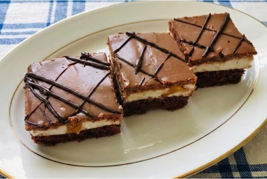 Meruňkový zákusek s jogurtovo-tvarohovou náplní: Svěží pokušení s čokoládou Meruňkový zákusek s jogurtovým krémem, kakaovým korpusem a čokoládovou polevou