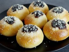 Domácí měkoučké koláčky s povidly, tvarohem a drobenkou na černém talíři.