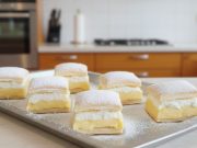 Domácí vanilkový kremeš s vysokou vrstvou šlehačky a lístkového těsta na bílém talíři