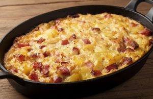 Zapečené zelí s bramborami a klobásou: Sytý oběd z jednoho pekáče Zapečené brambory s kysaným zelím, klobásou a šunkou: poctivý oběd z jednoho plechu