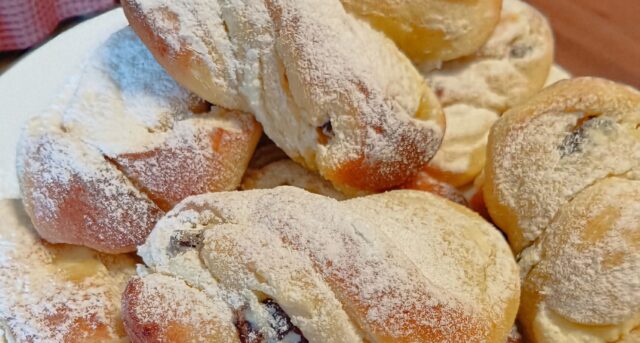 Pocukrované kynuté motánky na talíři.