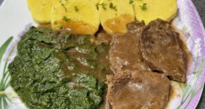 Poctivé hovězí na česneku se špenátem a bramborovým knedlíkem: Dokonalý sosík bez zahušťování Plátky pečeného hovězího masa přelité tmavým sosem na talíři, doplněné o porci zeleného krémového špenátu a plátky bramborového knedlíku.