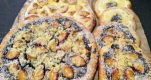 Poctivé kynuté koláče s tvarohem, mákem a slívami Dva velké a několik menších čerstvě upečených kynutých koláčů na pečicím papíře. Zdobené jsou makovou a tvarohovou náplní, plátky slív a bohatě posypané máslovou drobenkou a moučkovým cukrem.