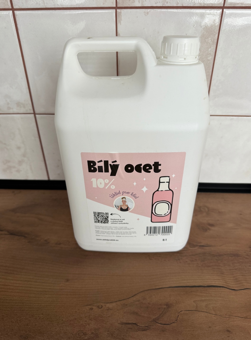 Plastový kanystr s 10% bílým octem o objemu 5 litrů stojící na kuchyňské lince.