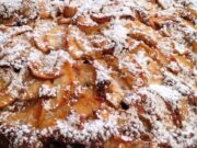 Neskutečně dobrý „překlopený“ koláč s jablky, rumovým krémem a posypkou Domácí jablečný koláč posypaný moučkovým cukrem s plátky jablek.