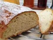 Vláčný podmáslový chléb z ošatky: Poctivý domácí bochník s vůní kmínu Bochník domácího chleba s křupavou kůrkou a nakrájenými plátky.