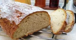 Vláčný podmáslový chléb z ošatky: Poctivý domácí bochník s vůní kmínu Bochník domácího chleba s křupavou kůrkou a nakrájenými plátky.