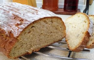 Vláčný podmáslový chléb z ošatky: Poctivý domácí bochník s vůní kmínu Bochník domácího chleba s křupavou kůrkou a nakrájenými plátky.