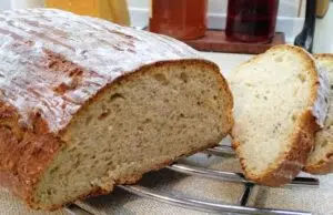 Vláčný podmáslový chléb z ošatky: Poctivý domácí bochník s vůní kmínu Bochník domácího chleba s křupavou kůrkou a nakrájenými plátky.