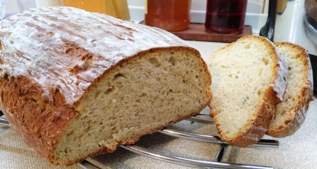 Bochník domácího chleba s křupavou kůrkou a nakrájenými plátky.