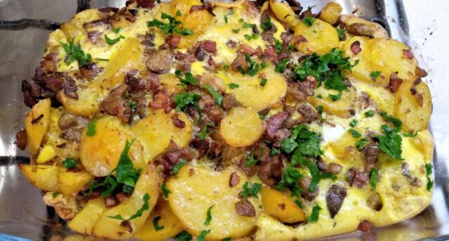 Zapečené brambory s masem, slaninou a bylinkami v pekáči.