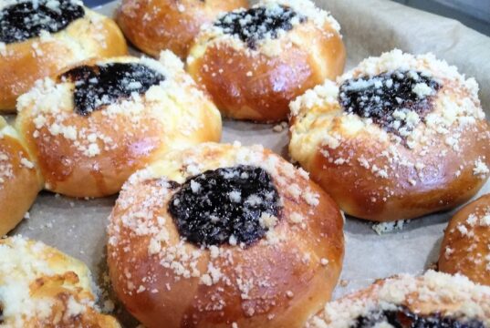 Dvojctihodné koláče s tvarohem a povidly: Tradiční recept, který provoní dům Kynuté koláče s tvarohem, drobenkou a ovocnou náplní na plechu.