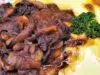 Pomalu pečená krkovička v pikantní marinádě: Maso, které se rozplývá Pečená vepřová krkovička s houbami a šťávou, podávaná s bramborovou kaší.