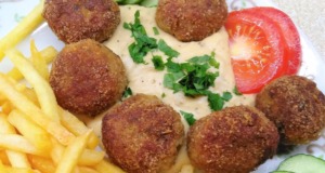 Šťavnaté krůtí kuličky s mozzarellou a krémovou hořčičnou omáčkou Smažené masové kuličky s omáčkou, hranolkami a zeleninovou oblohou.