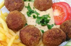 Šťavnaté krůtí kuličky s mozzarellou a krémovou hořčičnou omáčkou Smažené masové kuličky s omáčkou, hranolkami a zeleninovou oblohou.