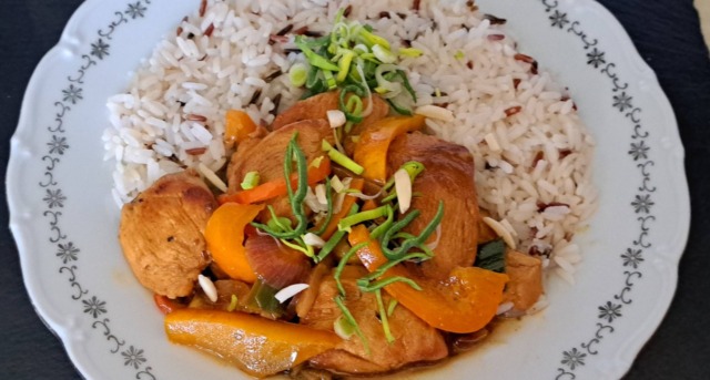Talíř s barevnými kuřecími fajitas (papriky, pórek, cibule a maso) podávaná s bílou rýží a čerstvým citronem.