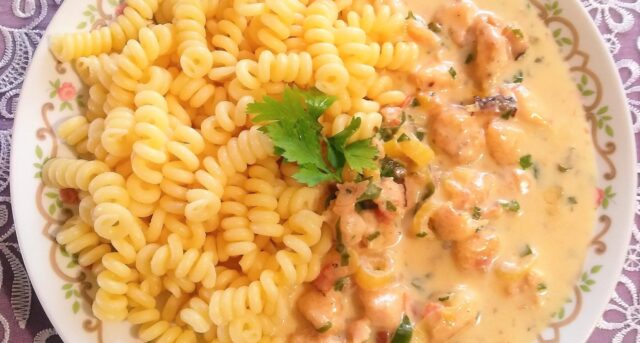 Krémová kuřecí směs se zeleninou podávaná s těstovinami fusilli.