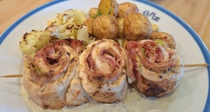 Luxusní kuřecí šneci se sýrovou omáčkou a ořechy: Recept pro gurmány Zlatavě opečení kuřecí šneci na špejli, přelití hustou smetanovou omáčkou s kousky nivy a vlašských ořechů, podávaní s pečenými brambory a květákem.