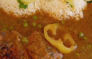 Šťavnatá vepřová kýta na hrášku s rýží: Rychlý recept na poctivý rodinný oběd Talíř s plátky dušené vepřové kýty v hnědé omáčce se zeleným hráškem, podávaný s kopečkem bílé rýže.