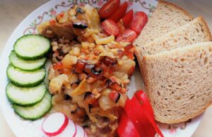 Pomalu pečená krkovice na cibuli a slanině: Poctivá dobrota z jednoho pekáče Pečená krkovice se zeleninovou směsí, chlebem a čerstvou oblohou.