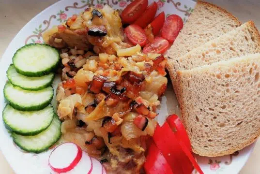 Pomalu pečená krkovice na cibuli a slanině: Poctivá dobrota z jednoho pekáče Pečená krkovice se zeleninovou směsí, chlebem a čerstvou oblohou.