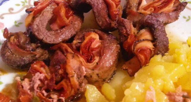 Grilované masové závitky se slaninou a zeleninou, podávané s bramborami.