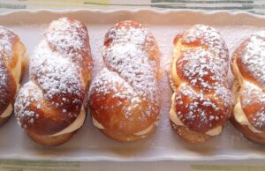 Domácí pudinkáče: Nadýchané pletýnky s jemným vanilkovým krémem Kynuté buchty plněné krémem, posypané moučkovým cukrem.