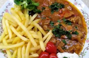 Rozlítané ražničí z pomalého hrnce: Poctivá chuť bez pletení jehel Masová směs na způsob ražniči s hranolkami, zeleninou a bylinkami.